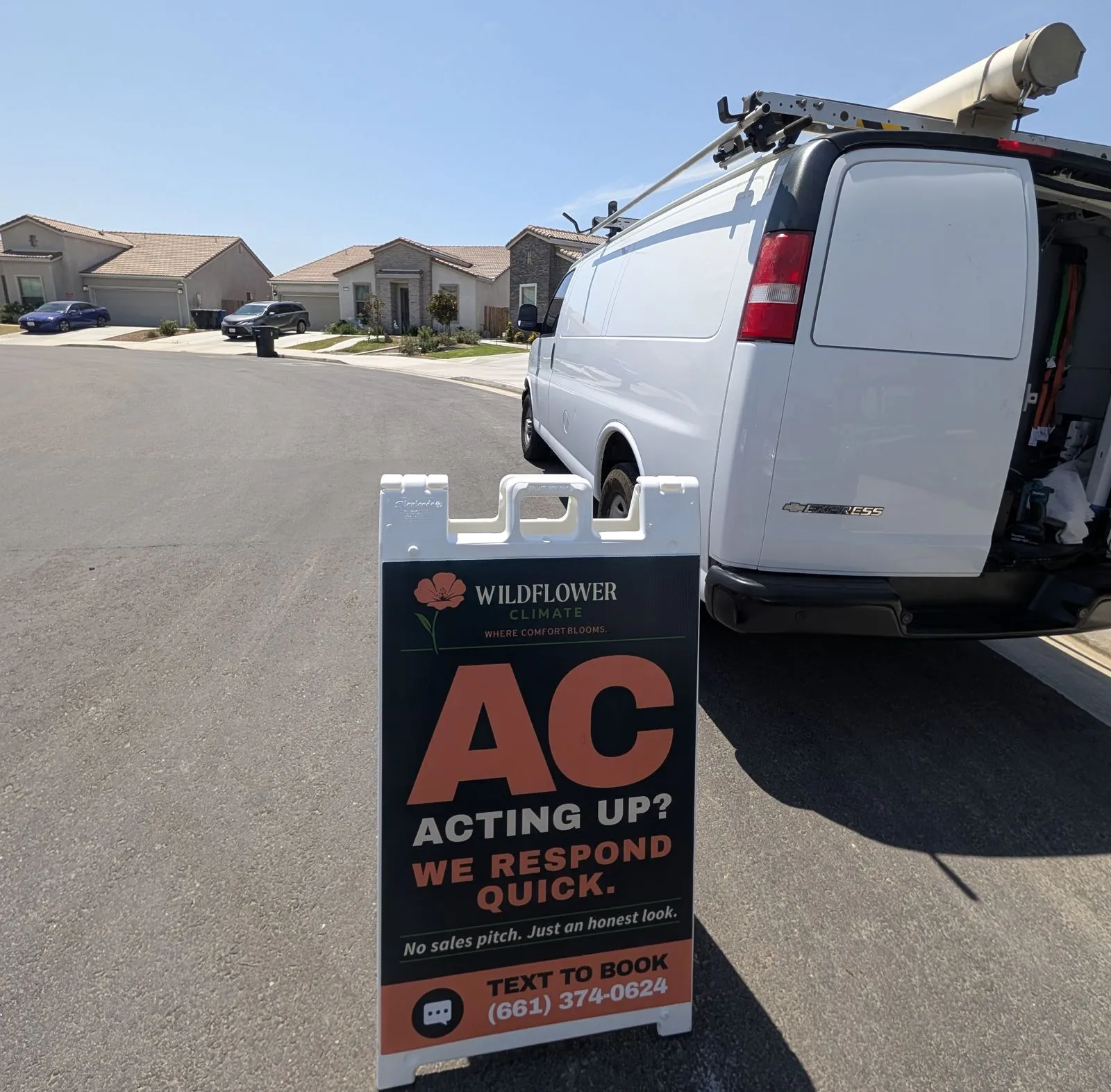 The Wildflower Climate van and a sidewalk sign reading AC acting up, we respond quick, parked on a Bakersfield street